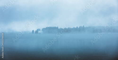 A wintery scene looking over a blue lake in the snow in New Zealand.