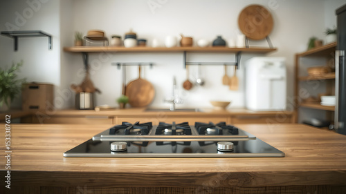 Wooden table surface with modern stove top on blurred background of modern kitchen interior with shelves with tableware