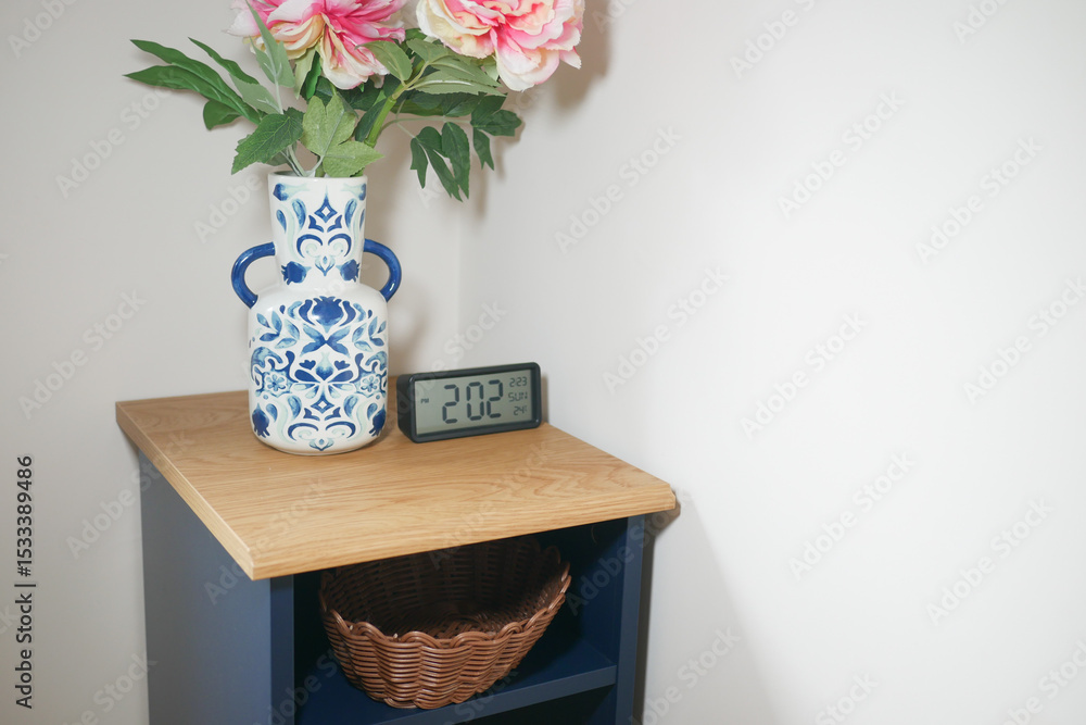Decorative vase with flowers and clock on wooden shelf Decorative vase with flowers and clock on wooden shelf