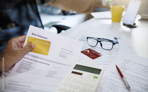 Foto asian man holding credit card with bank statement calculating expenses and check