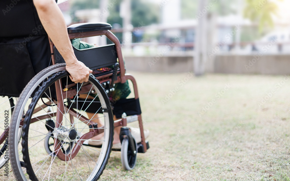 Obraz premium cropped shot, middle age female on wheelchair on grass field at home she resting after being sick