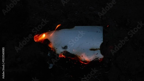 Burning and glowing photo or paper with fire flame and smoke on dark background