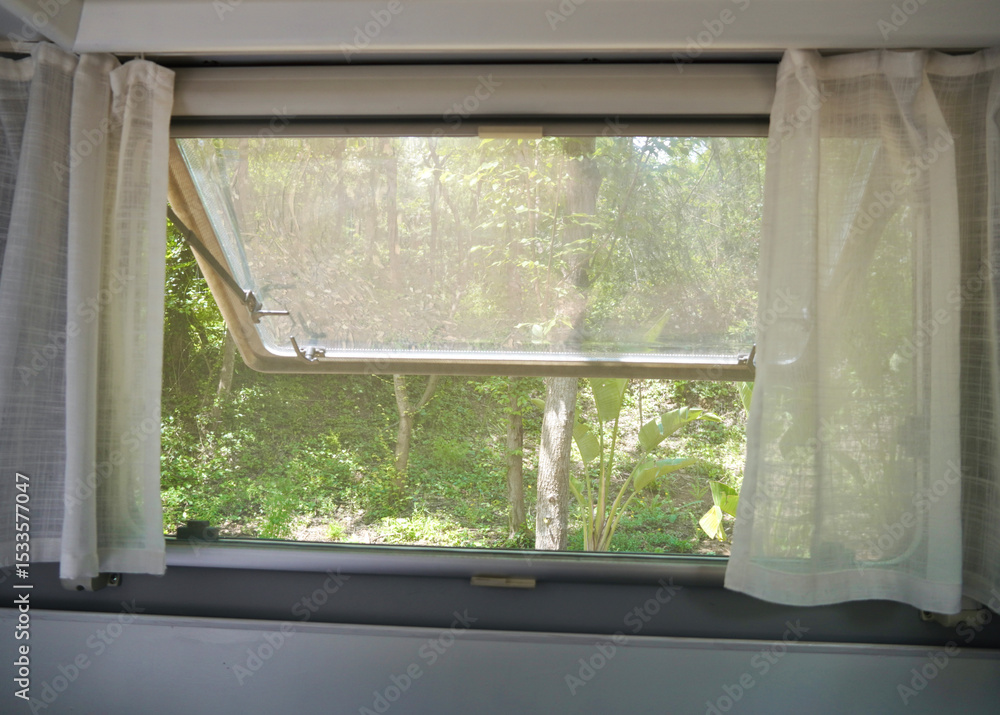 Fototapeta premium Summer Breeze Through Camper Window with Mesh Screen.