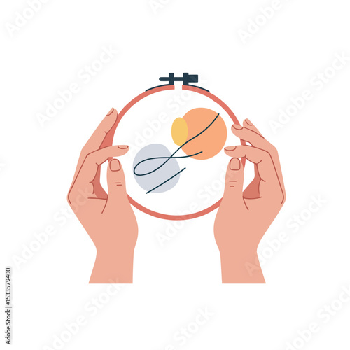 Hands holding embroidery hoop with colorful design for stitching  