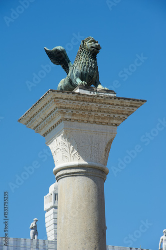 Winged lion of venice statue perched atop column in piazza san marco