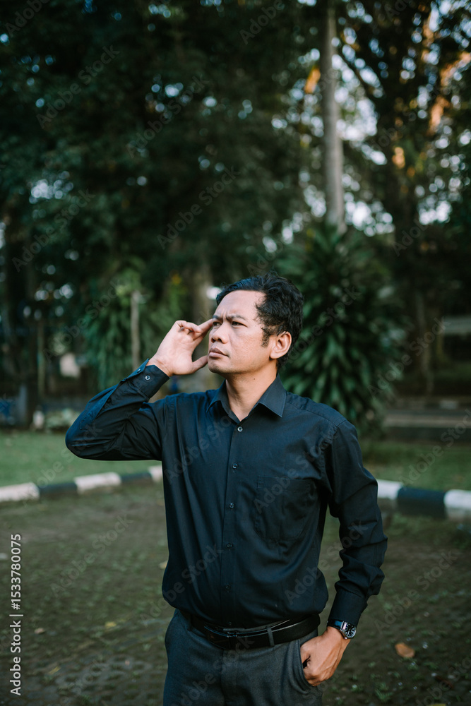 Pensive man in a park contemplating solution with hand on forehead Pensive man in a park contemplating solution with hand on forehead