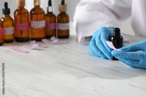 Foto Professional perfumer developing luxury perfume at white wooden table in laborat