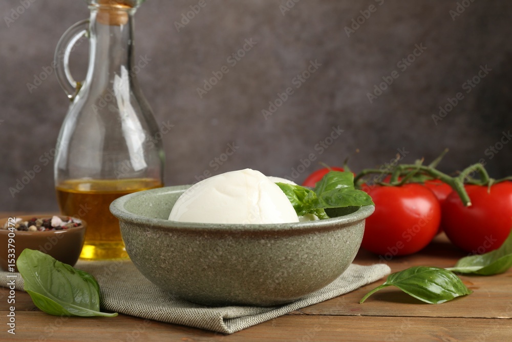 Tasty mozzarella balls, tomatoes, oil and basil on wooden table, closeup Tasty mozzarella balls, tomatoes, oil and basil on wooden table, closeup