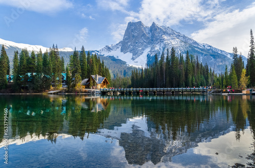 Idyllic Emerald Lake in Yoho National Park with snow-capped mountains and pine forests with charming lodge reflected in the turquoise water in Alberta, Canada