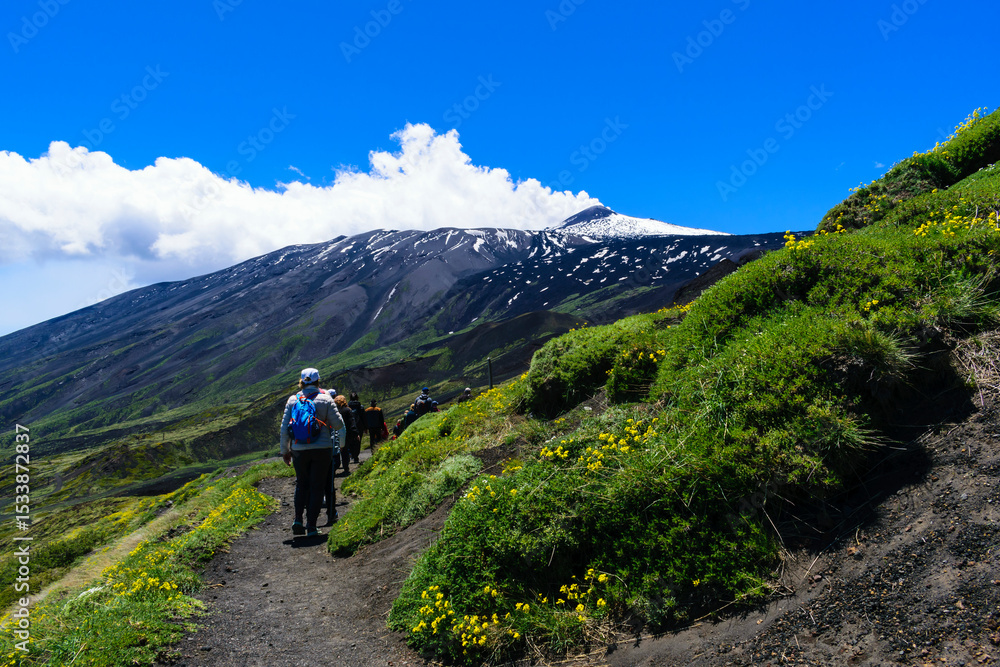 Fototapeta premium Hikers on Mount Etna Against a Dramatic Landscape