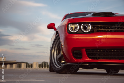 Front view of a powerful red sports car at the parking lot