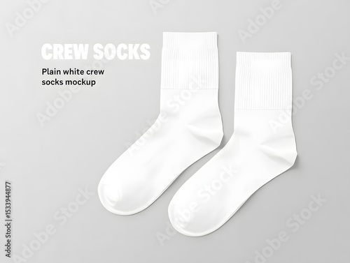 A pair of pristine white crew socks lies flat against a neutral gray background, ready for a fresh start