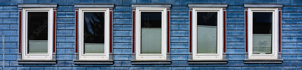 Fototapeta premium Fünf Fenster an einem Holzhaus