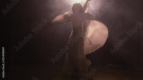 Young woman dancing gracefully in moonlight forest
