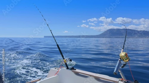 Sport boat trolling ocean with rods, reels, saltwater outboard fishing