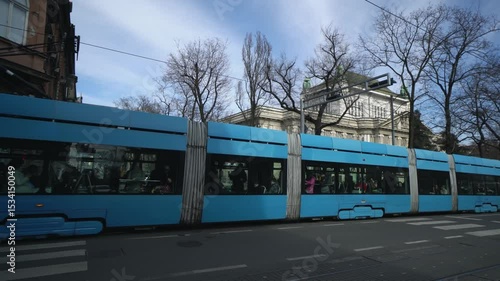 Blue tram passing near Croatian State Archives in central Zagreb street