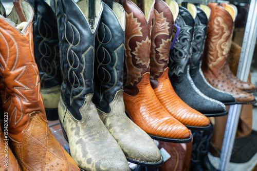 Handcrafted Mexican cowboy boots in various exotic leathers and colors displayed in a traditional Guadalajara market stall