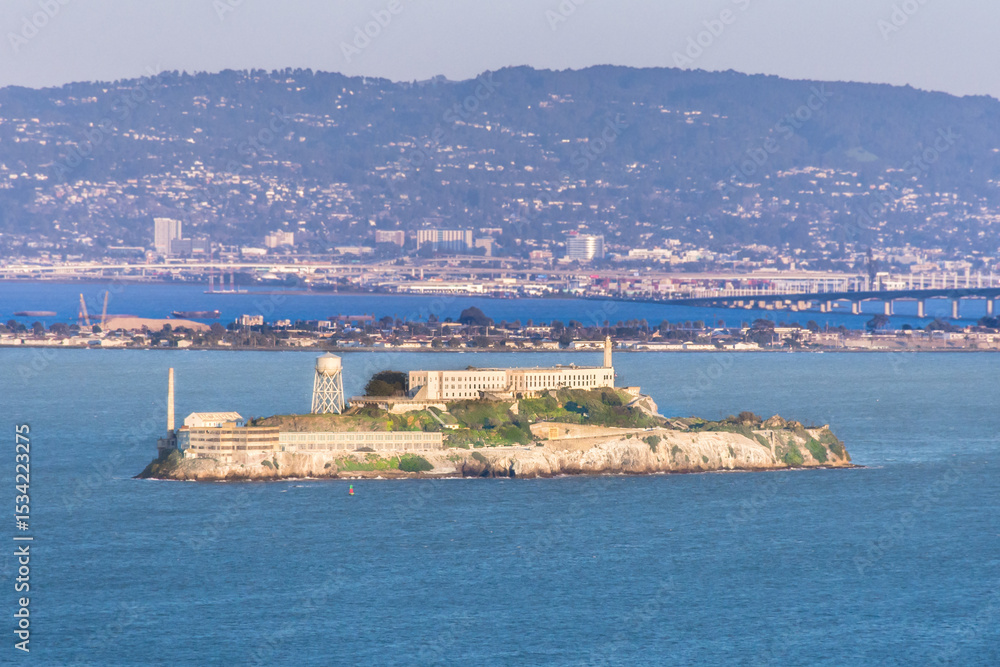 Fototapeta premium Alcatraz island in San Francisco Bay at sunset showing prison and headlands in the background