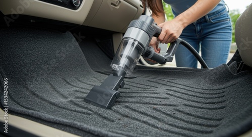 Cleaning Car Interior: A Woman Using a Handheld Vacuum to Clean Car Mats