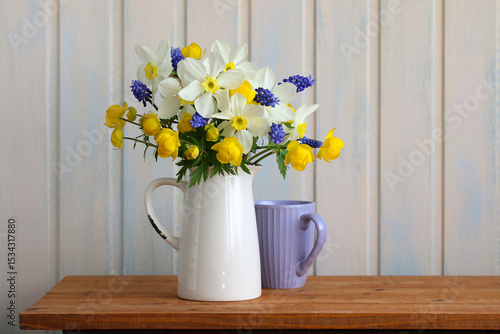 Fototapeta Naklejka Na Ścianę i Meble -  Spring flowers bouquet in white jug decorating wooden table