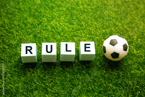 Soccer and football rules; Ball with rule word on green soccer field