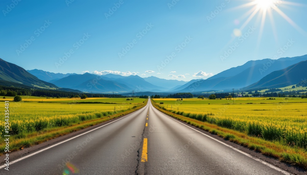 Naklejka premium capture a serene outdoor landscape with a straight asphalt street cutting through lush green fields, framed by majestic mountains under a clear blue sky