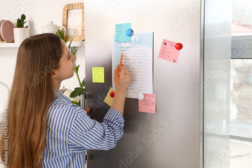 Young woman making to-do li...