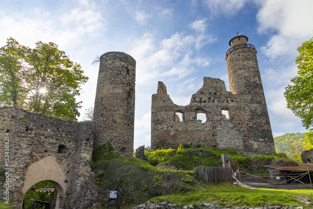 Ruins of Kostomlaty Castle under Milesovka, Czech Republic, standing tall against a blue sky Ruins of Kostomlaty Castle under Milesovka, Czech Republic, standing tall against a blue sky