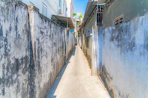 Fototapeta Naklejka Na Ścianę i Meble -  The streets of a small town.

Vietnamese neighborhoods of Nha Trang city in Vietnam. Narrow small streets with low-rise apartment buildings. 