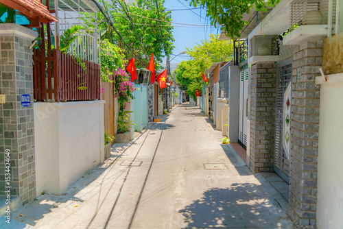 Fototapeta Naklejka Na Ścianę i Meble -  The streets of a small town.

Vietnamese neighborhoods of Nha Trang city in Vietnam. Narrow small streets with low-rise apartment buildings. 