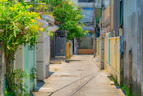 Fototapeta Naklejka Na Ścianę i Meble -  The streets of a small town.

Vietnamese neighborhoods of Nha Trang city in Vietnam. Narrow small streets with low-rise apartment buildings. 