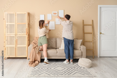 Young couple hanging blank ...