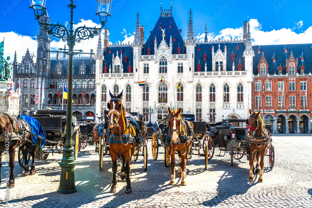 Fototapeta premium Bruges, Belgium. Horse carriages on Market square in Brugge old town, Bruges city historical centre