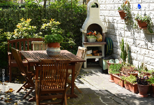 A relaxing outdoor living space with wooden garden furniture and built in stone barbecue area