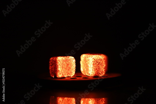 Glowing coals with glitch style lighting, enriched by noise, effect and grain details, create a mystical atmosphere in the dark. A vivid sense of heat and depth surrounds the image