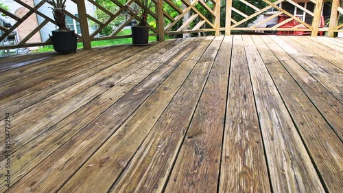 Wooden deck, weathered dirty wood planks at residential home house exterior potted plants, flower pots outside outdoors garden
