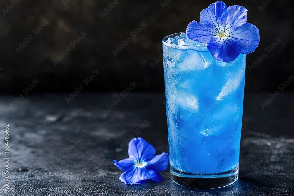 Vibrant blue cocktail garnished with edible flowers. Vibrant blue cocktail garnished with edible flowers.