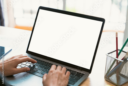 Businessman hand typing on laptop and working on computer on wooden table, screen blank mockup.