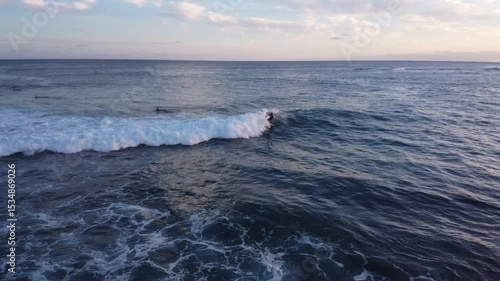 Surfer riding a wave at sunset