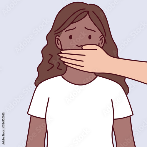 Black dark brown skinned woman in white shirt is silenced by a hand. Her eyes are wide in fear. Visual symbol of threat, violence, and suppression