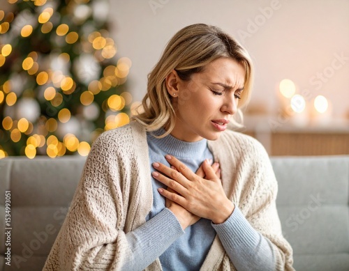 Woman experiencing chest pain near christmas tree