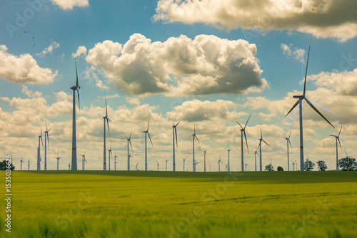 Modern wind turbines spinning over vibrant green fields in rural Germany. A powerful symbol of the Energiewende and Germany’s response to climate change and energy transition. green energy