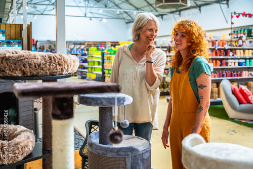 Foto Senior woman choosing cat tree with shop assistant help