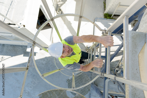 Obraz na plátně man climbing a fixed ladder of a telecommunication tower