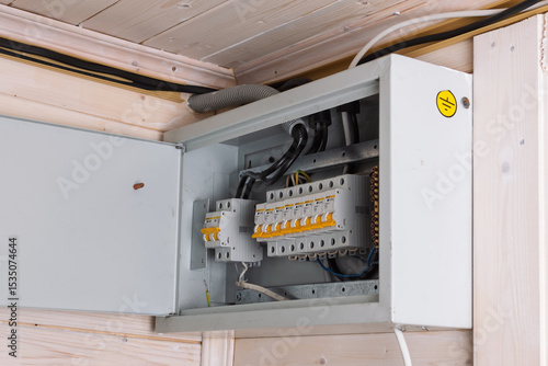 Cuadro en lienzo A modern electrical distribution board with open metal door reveals neat wiring, multiple circuit breakers, and well-organized cables in a wooden house interior