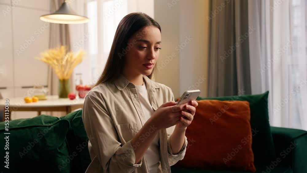 Caucasian woman using mobile phone at home concentrated girl female chatting texting smartphone chat booking service order food delivery in living room online app social media use internet shopping