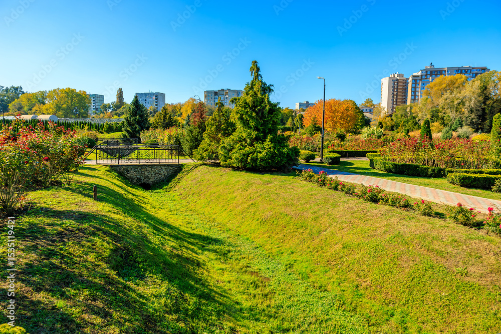 Fototapeta premium A park with a grassy hill and a bench