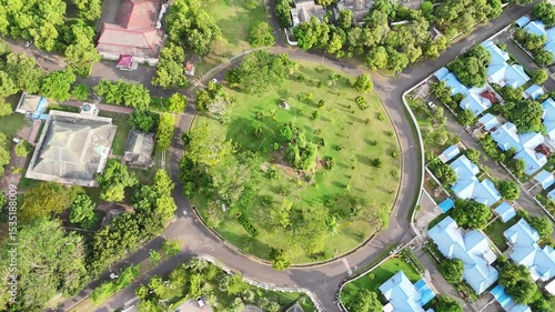 Aerial view shows a circular park with roads buildings and vegetation