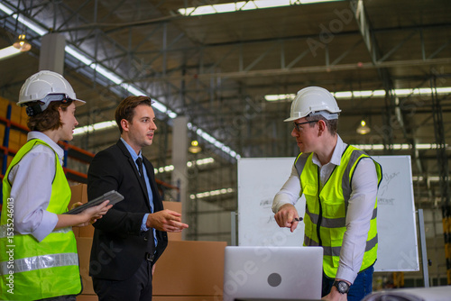 Blue collar workers are working and meeting at warehouse.