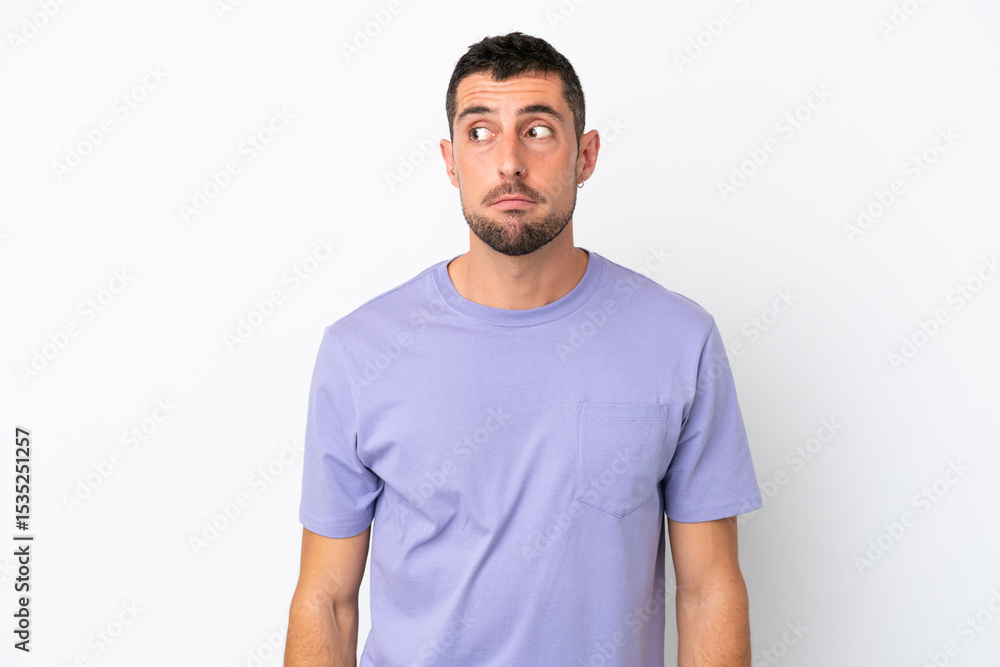 Young handsome caucasian man isolated on white background making doubts gesture looking side Young handsome caucasian man isolated on white background making doubts gesture looking side
